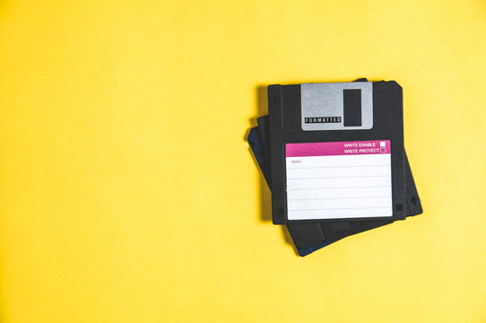 Old floppy disks for computer on yellow background