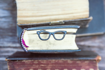 Vintage books and bookmark glasses on a wooden background