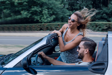 Couple of lovers driving on a convertible car