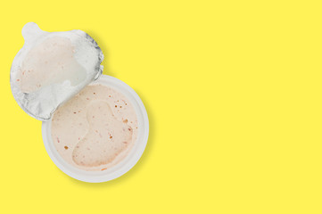 Single plastic jar of pate on yellow background with copy space for your text