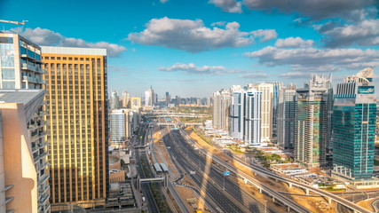 Fototapeta premium Aerial view of Dubai marina skyscrapers and Jumeirah lakes towers timelapse with traffic on sheikh zayed road.
