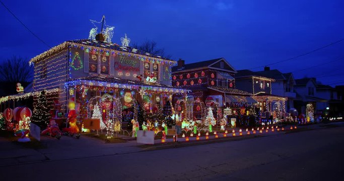 A three-quarter wide establishing shot of houses heavily decorated for Christmas on an early winter evening. Pittsburgh suburbs.  	