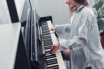 cropped view of musician playing piano and smiling in living room © LIGHTFIELD STUDIOS