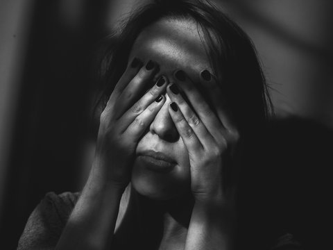 Depressed woman in shadows. Black and white.