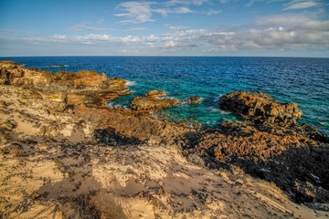 Meereslandschaft auf der Kanareninsel Lanzarote mit Felsküste vor klarem Meerwasser im Sonnenschein
