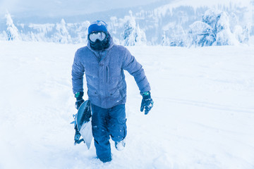 Fototapeta na wymiar the man in the mountain snow snowboard. man holding a Board.