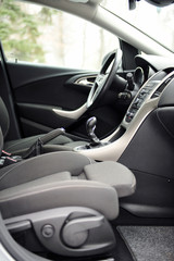 Modern luxury prestige car interior, dashboard, steering wheel. Black perforated leather interior.