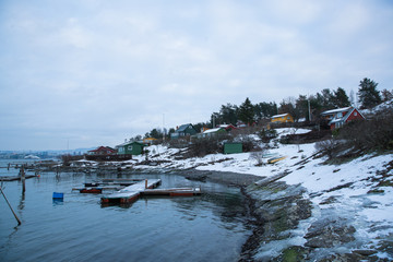 Traditional cottages on the islands around Oslo Norway during the winter overlooking the sea and the Fjord in snow condition