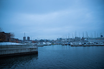 Oslo Norway coast during winter with a large number of docked boats in the center of the city covered with snow