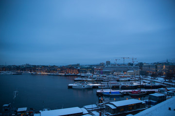 Fototapeta premium Oslo Norway coast during winter with a large number of docked boats in the center of the city covered with snow