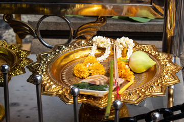 incense sticks, flower garland and lotus bud on golden tray as offering for buddha
