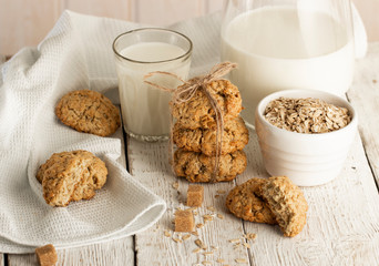 Oatmeal cookies with milk on tray on rustic wooden table