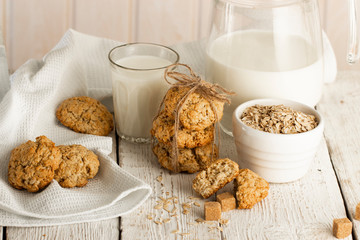 Oatmeal cookies with milk on tray on rustic wooden table