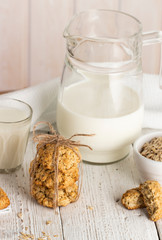 Oatmeal cookies with milk on tray on rustic wooden table