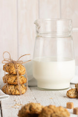 Oatmeal cookies with milk on tray on rustic wooden table