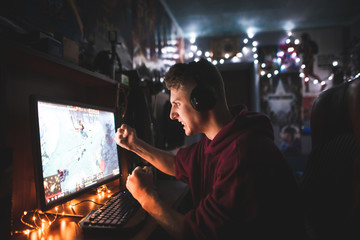 Angry teenager gamer plays video games at home on a computer, looking angry at the screen....