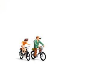 Miniature people : Couple ride bicycle on white background