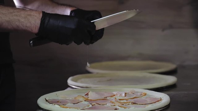 Chef puts the ingredients in pizza: breaks an egg