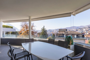 Lounge terrace composed of chairs and table overlooking the city of Lugano in Switzerland