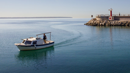 Barca entrando en puerto con un mar en calma