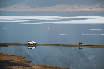 Couple walking on the road with mirror water