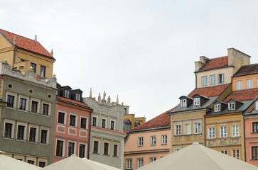 Fototapeta na wymiar White umbrellas and colorful buildings in Warsaw, Poland
