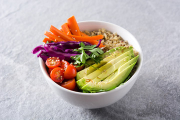 Vegan Buddha bowl with fresh raw vegetables and quinoa on gray background