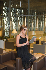 Business young woman in glasses works at a table in a cafe.