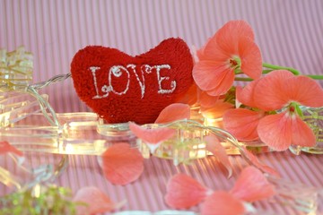 Valentine's day.Red heart and lights garland on pink background.