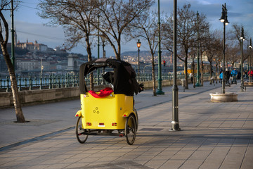 Rickshaw yellow wagon on a riverfront promenade of Budapest, Hungary