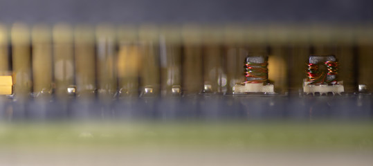 Close up (Macro) of Printed Circuit Board PCB embedded components (inductors, resistors, capacitors, diodes, microchips, transistor) with short depth of view. 