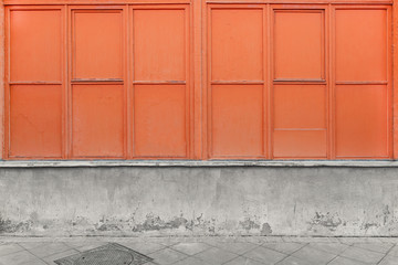 Gray concrete wall with damage and painted window frame in peach color. Colored wall with wooden frame without window glass.