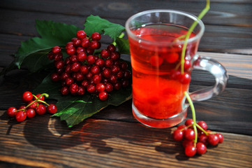 Berries of a viburnum on a wooden surface. Drink from the viburnum. View from above
