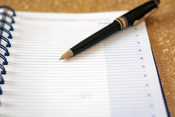 Naklejka premium a black pen on an open notebook