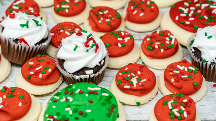 Variety of Christmas holiday treats with chocolate cupcakes and buttercream iced sugar cookies