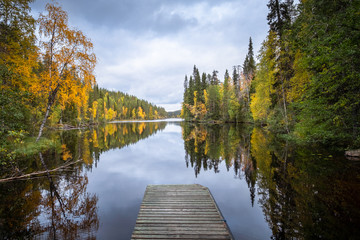 Autumn landscape with idyllic lake and fall colors at daytime in Hossa, National Park, Finland.