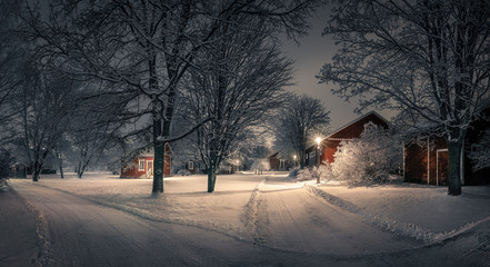 Public park with cozy cafe place and snow covered trees at winter evening in Finland. Cafe place is...