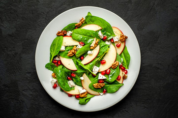 Spinach Salad, Apple, Pomegranate, Cheese, Walnut Salad on Concrete, Slate Background