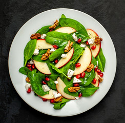 Spinach Salad, Apple, Pomegranate, Cheese, Walnut Salad on Concrete, Slate Background
