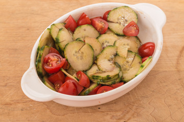 Cucumber and Tomato Salad in White Dish on Cutting Board