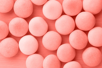 Small round candy living coral pastel background.