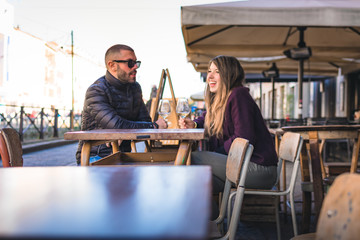 Ragazzo e ragazza si incontrano in un bar sui Navigli di Milano