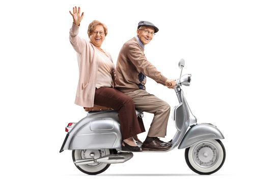 Fototapeta Senior couple riding a vintage scooter and waving