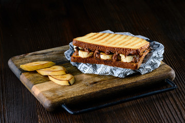 Delicious natural and diet sandwich banana with chocolate on a rustic background