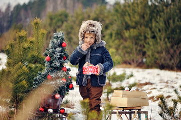 Child in winter. Fun little boy in the snow. The child is playing outside. Winter background....