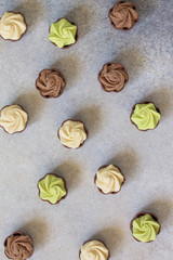 Yummy Assortment chocolate candies. Chocolate with vanilla, chocolate and pistachio cream on marble background. Top view flat lay background.