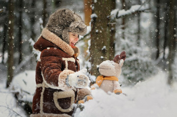Child in winter. Fun little boy in the snow. The child is playing outside. Winter background....