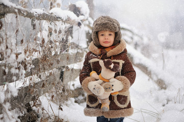 Child in winter. Fun little boy in the snow. The child is playing outside. Winter background. Beautiful, original winter photos.