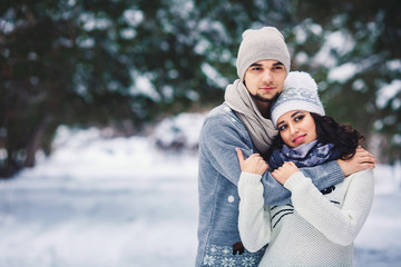 man and girl in sweaters hugging in the park in winter. winter walk, rest.