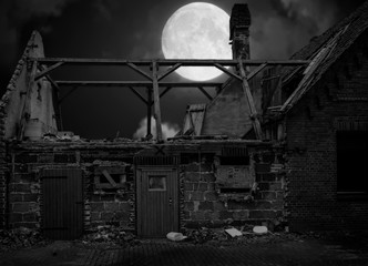 Unbewohntes altes abbruchreifes Haus mit Mond im Hintergrundlicht